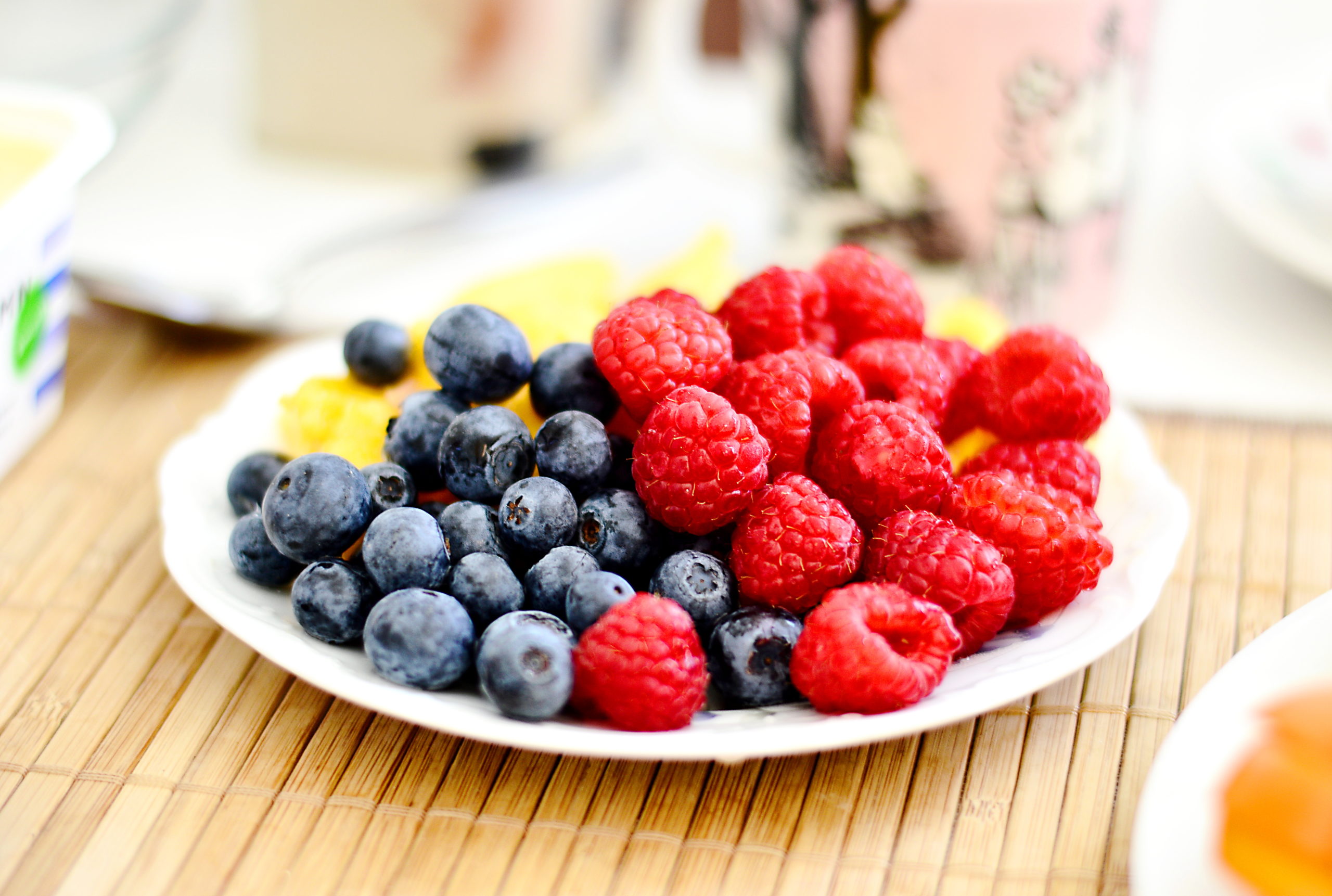 plate of blueberries and raspberries for lowering cholesterol