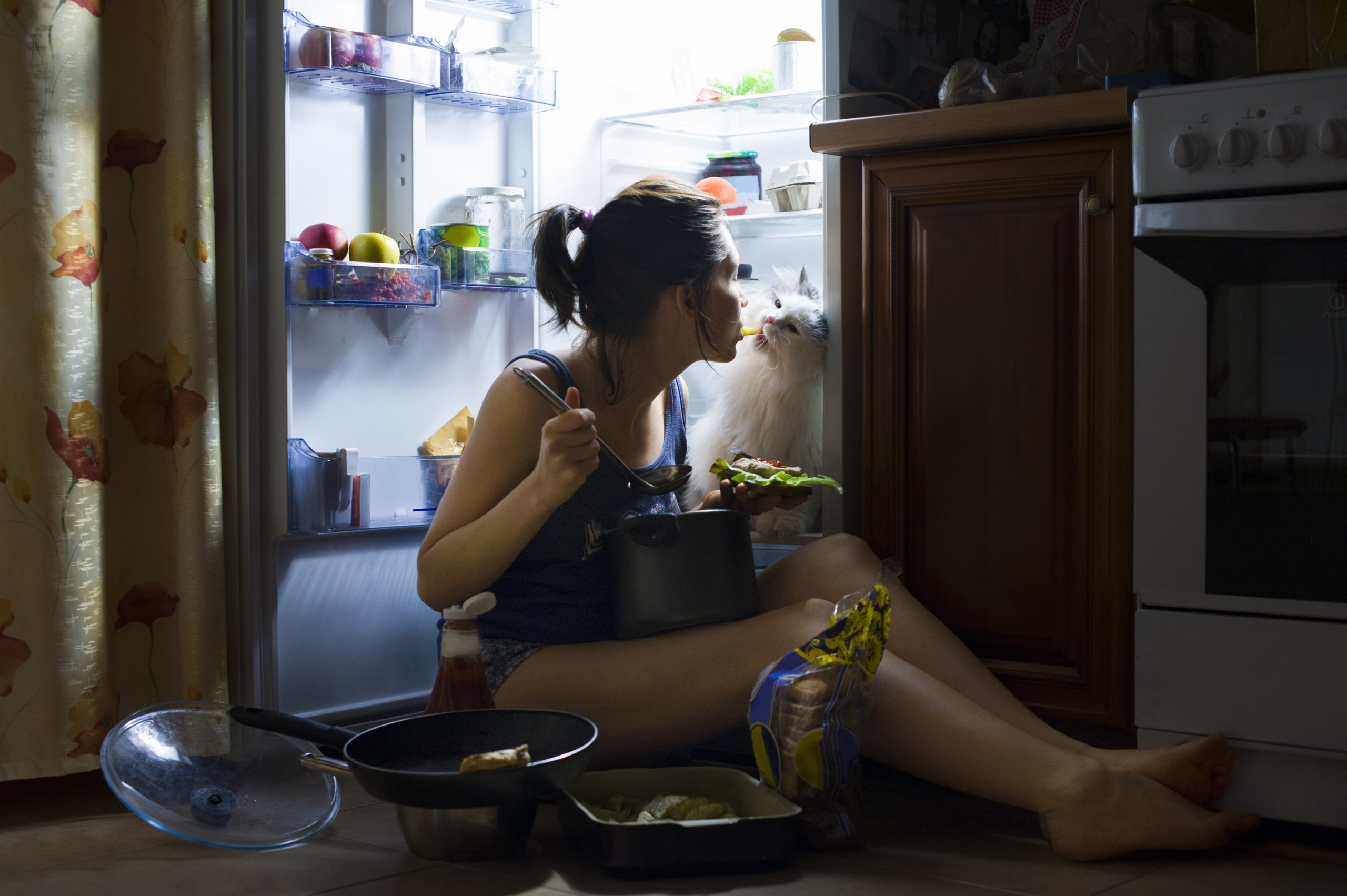 Как ни есть на ночь. Человек ест ночью. Девушка у холодильника ночью. Женщина ест ночью. Поздний ужин.